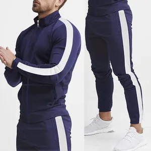 Detail of navy men's slim fit tracksuit with white side stripes on sleeves and legs.