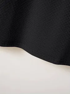Macro view showing the intricate black honeycomb weave texture of a heavy polo shirt