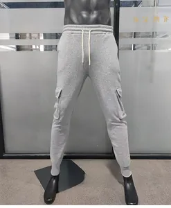 Detailed view of men's grey cargo sweatpants with multi-pockets and drawstring