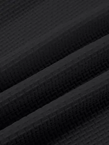 Detailed macro shot of high-quality heavy black textured waffle knit polo shirt fabric