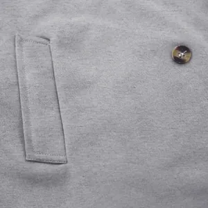 Close-up detail of grey men's slim windbreaker with textured pocket and button