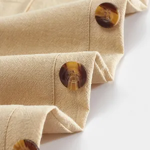 Gros plan d'un pantalon en coton et lin pour homme avec boutons décoratifs en corne.