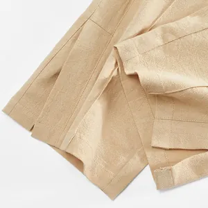 Détail de l'ourlet d'un pantalon d'homme en coton et lin avec des coutures soignées et tissu