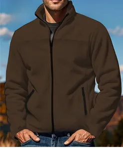 Detail of men's brown zip-up outdoor jacket with stand collar and pocket zippers.