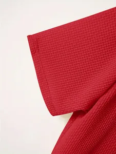 Close-up detail of red waffle-textured short sleeve on a men's heavy polo shirt