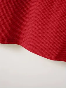 Close-up of red waffle textured fabric and durable hem on men's heavyweight polo shirt