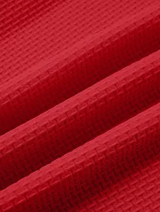 Macro close-up of the vibrant red waffle knit fabric texture on a heavyweight polo shirt