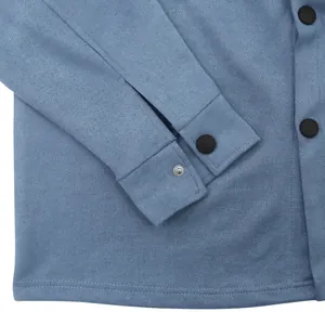 Detailed macro shot of a blue faux suede jacket showing cuff texture and snap buttons