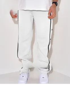 Detail of men's white straight leg sweatpants with black side stripes and snap buttons