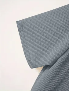 Detailed close-up of grey waffle texture fabric on a men's heavy weight short sleeve polo shirt