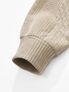 Detailed close-up showing the ribbed cuff and jacquard texture of a beige men's cardigan.
