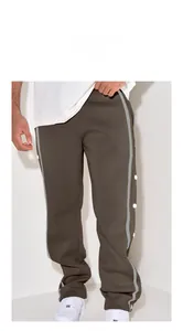 Model wearing men's loose brown straight-leg sports trousers with side buttons