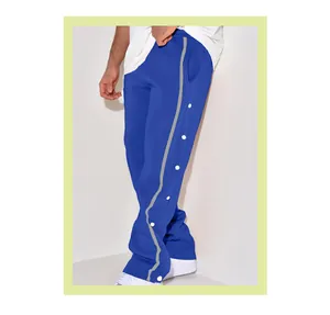 Detail view of men's royal blue joggers with white side snap buttons and stripe.