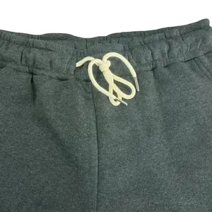 Close-up of mens grey athletic sweatpants featuring an elastic waist and drawstring.