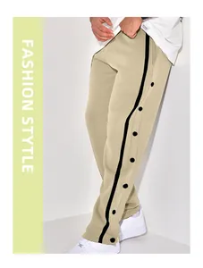 Detail of khaki wide-leg track pants with black side buttons and side stripe design