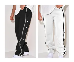 Detailed view of men's loose straight-leg sports pants featuring side snap buttons and stripes