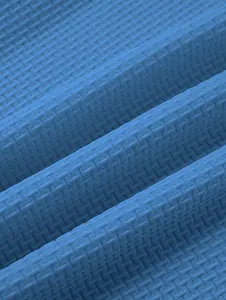 Macro detail view of blue textured waffle knit fabric for premium heavy cotton polo