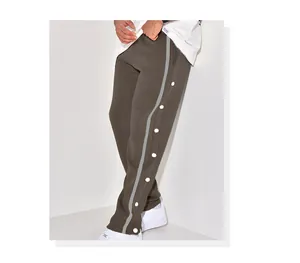 Detailed view of men's button-up side snap track pants with reflective stripe
