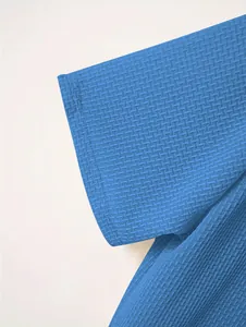 Close-up detail of blue waffle-knit texture on heavyweight men's polo shirt