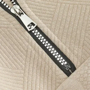 Primo piano di una cerniera in metallo argentato su tessuto beige testurizzato