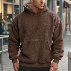 Macro view of a men's thick brown sherpa fleece hoodie showing texture and pocket