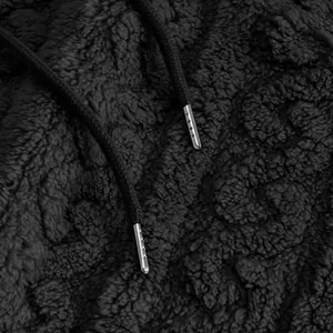 Macro detail of black sherpa fleece fabric and metal-tipped hoodie drawstrings