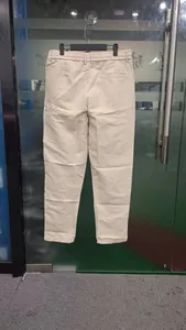 Gedetailleerd achteraanzicht van beige heren vrijetijdsbroek hangend aan een glazen deur