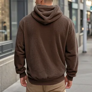 Detailed back view of a cozy oversized brown fleece hoodie in a stylish urban street setting