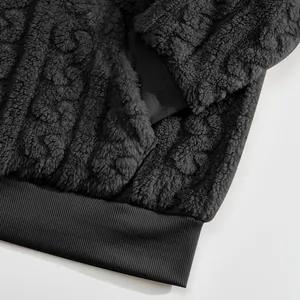Close-up of warm jacquard fleece hoodie showing ribbed hem and soft texture details.