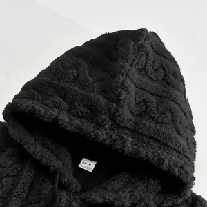 Close-up view of black jacquard fleece hoodie texture showing the plush fabric and hood details