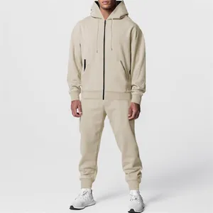 Tuta da uomo beige in due pezzi con giacca con cappuccio e zip e pantaloni.