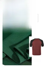 Close-up detail of breathable green fabric texture and stylish color-blocked raglan t-shirt
