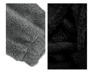 Macro primo piano della morbida consistenza del tessuto in pile grigio e nero della felpa.