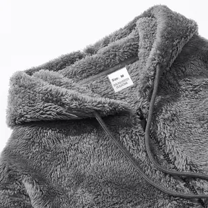 Macro view of grey fleece zip-up hoodie showing fuzzy texture and internal size label