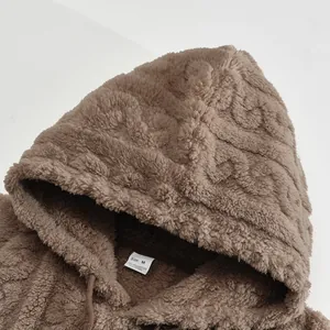 Close-up of brown jacquard teddy fleece hoodie showing soft texture and interior size label