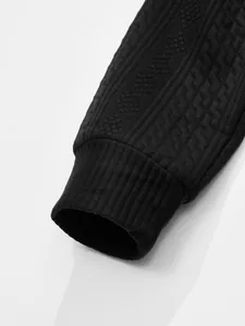 Detail shot of men's retro black knitted cardigan featuring 3D jacquard and rib cuff.