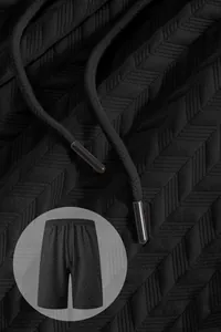 Macro view of black men's shorts with textured jacquard pattern and drawstrings