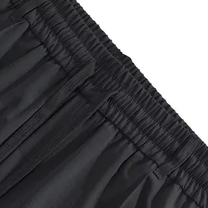 Vista dettagliata dei pantaloni sportivi neri da uomo con elastico in vita e coulisse nera.
