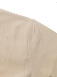 Detailed macro view of beige linen fabric texture and durable shoulder seam on men's top