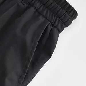 Vista dettagliata della vita elastica e della tasca laterale dei pantaloni sportivi