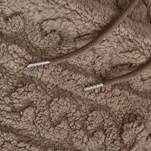 Detailed macro view of high-quality brown sherpa fleece fabric and metallic drawstring tips