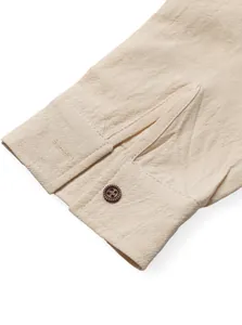 Close-up detail of a men's linen long-sleeved shirt cuff with a textured brown button.