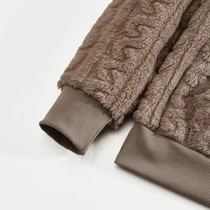 Close-up of ribbed cuffs and jacquard fleece texture on a brown men's pullover hoodie