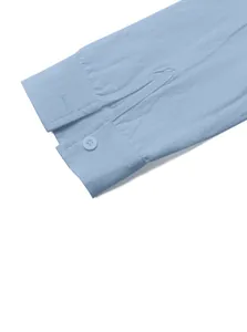 Close-up detail of light blue linen shirt cuff with single button and woven texture