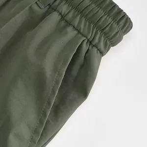 Primo piano di pantaloni sportivi da uomo verde oliva con elastico in vita e tasche