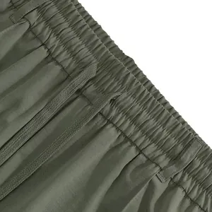 Dettaglio dell'elastico in vita con coulisse dei pantaloni sportivi da uomo verdi.