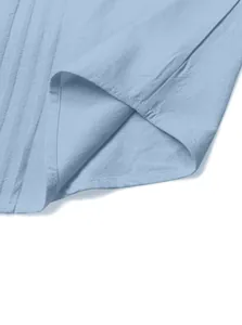 Close-up detail of light blue woven linen fabric texture and neat stitching on shirt hem