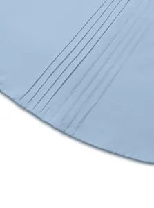 Close-up detail of light blue linen woven shirt featuring vertical pin-tucks and fabric texture