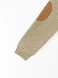 Close-up view of men's waffle knit hoodie sleeve with contrast elbow patch detail