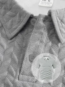 Detailed view of gray men's polo shirt showing textured jacquard weave and buttons